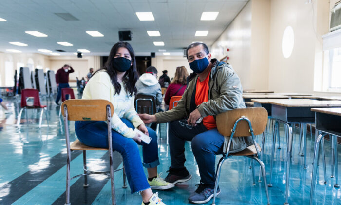 Evelyn Avila waits the required 15 minutes alongside her dad after receiving her first dose of a COVID vaccine at a Catholic Charities popup event held at Saint Frances of Rome School. May 15th, 2021 in Cicero, Ill (Photo by Abel Rodriguez).