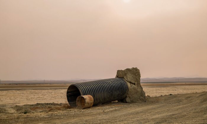 A pipe remnant from an old water movement infrastructure system sits abandoned next to the Blakeley Canal in Kings County, California, as smoke from forest fires fills the valley sky.