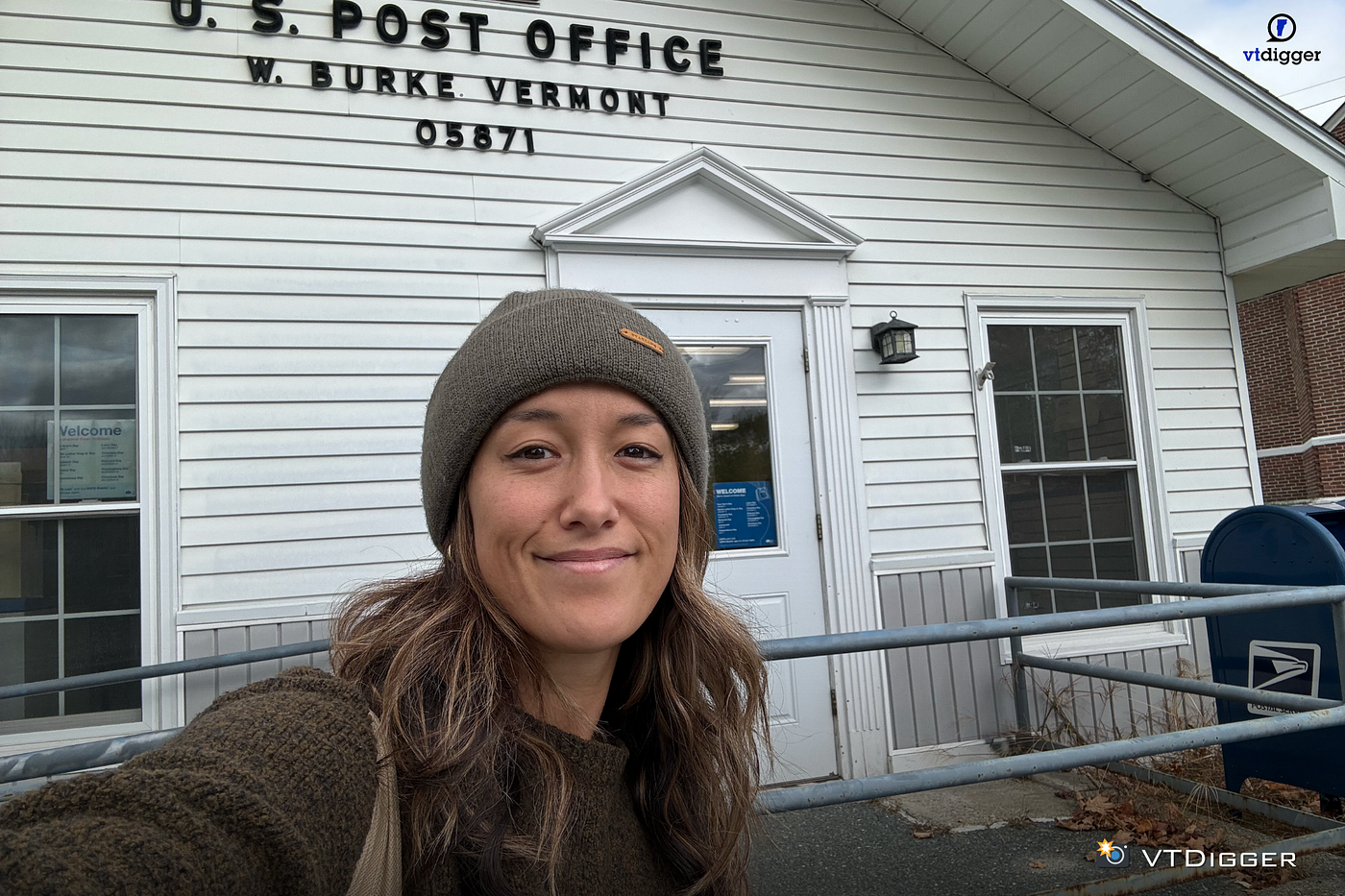 Libbie Sparadeo, director of membership and engagement at VTDigger, drops postcards at a rural Vermont post office.