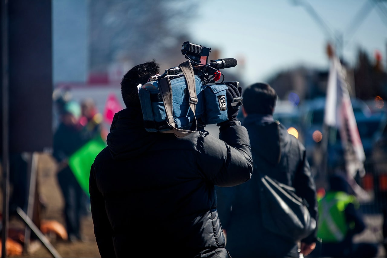 Man carrying professional camera on his shoulder